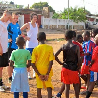A group of volunteers teaching rugby in Ghana chat to their team Projects Abroad volunteers hold a team meeting during volunteer rugby coaching in Ghana